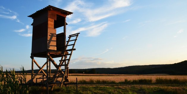 A wooden raised hide for hunting with a spotting scope.