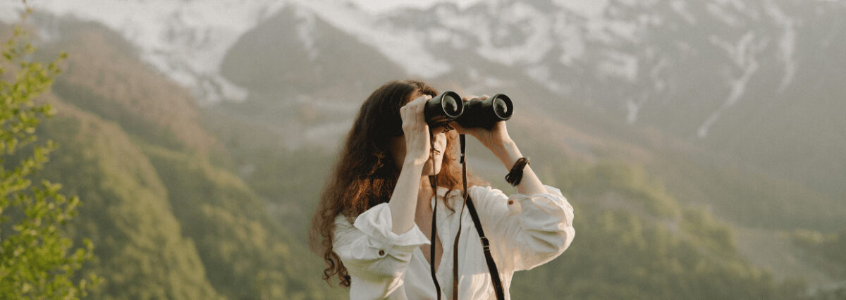 Eine Frau schaut durch ein Fernglas.